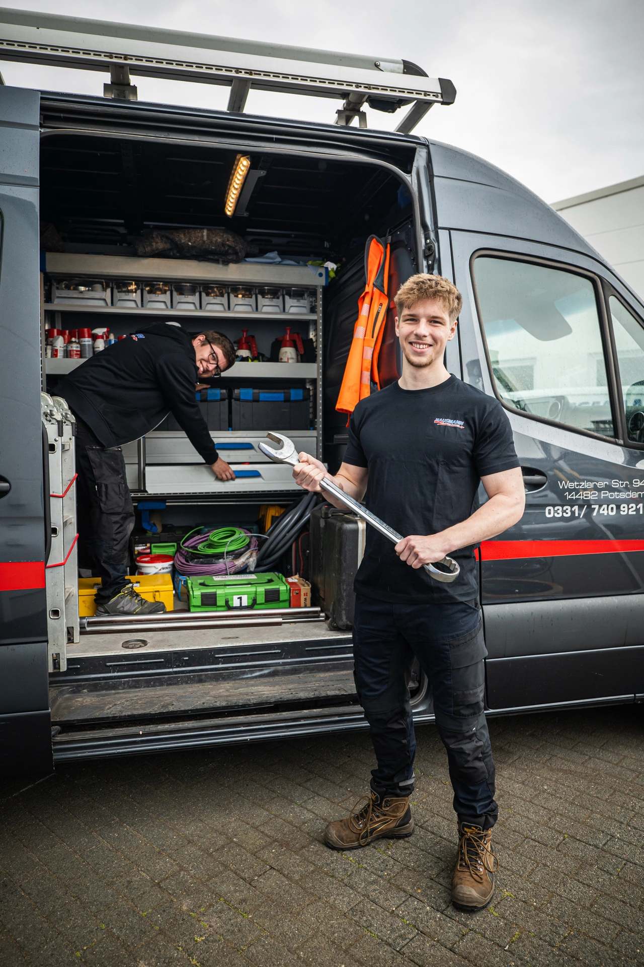 Ein Monteur steht am offenen Transporter