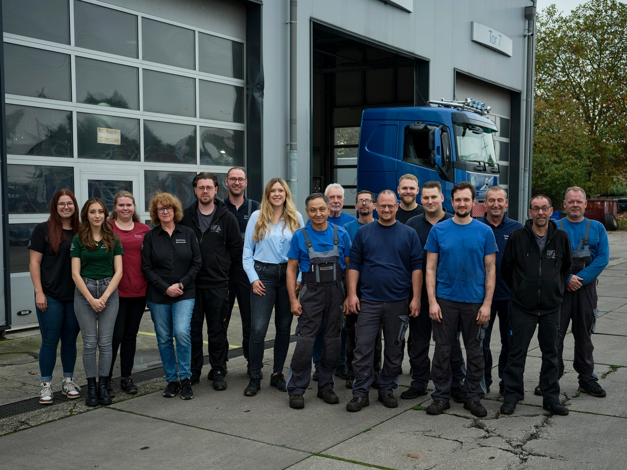 Eine große Belegschaft steht vor der Werkshalle