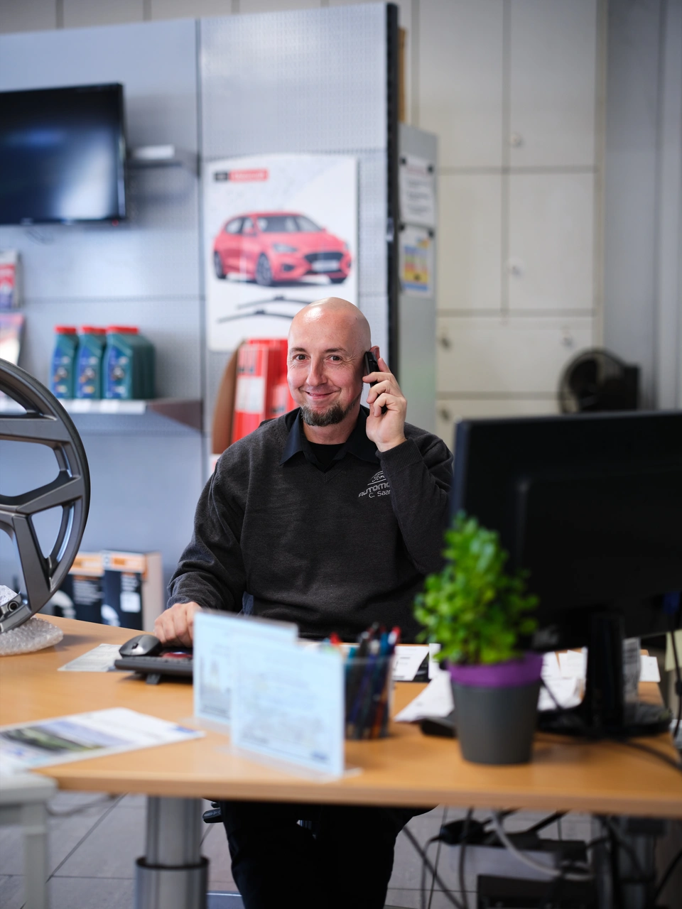 Ein Mann telefoniert an seinem Schreibtisch im Büro