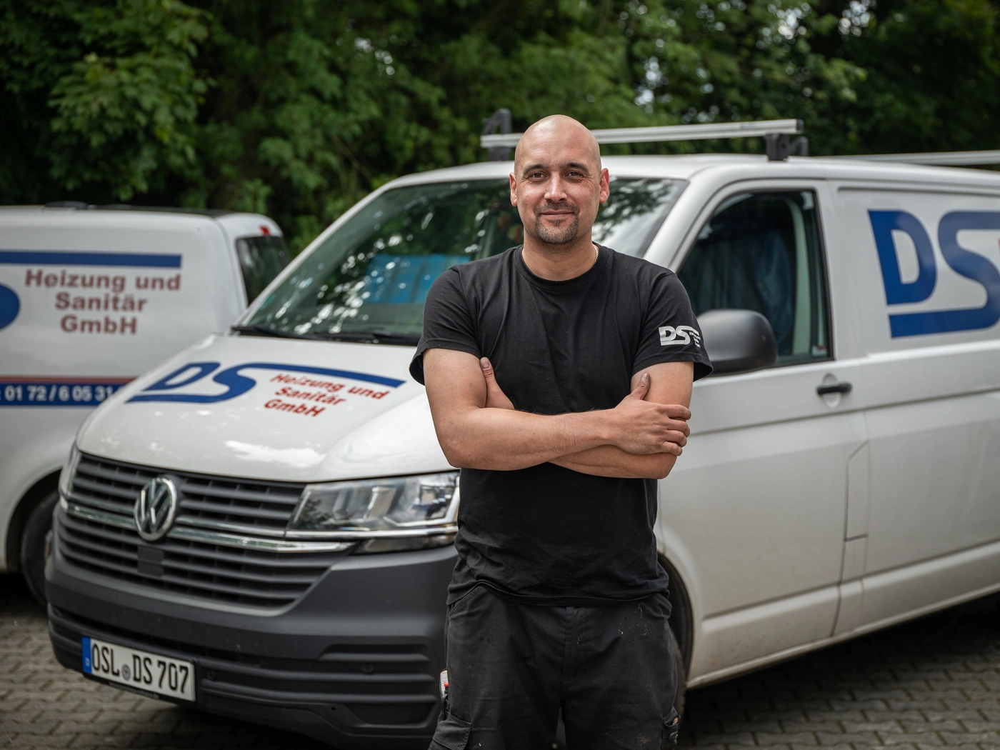 Anlagenmechaniker vor einem Servicewagen für Heizung und Sanitär