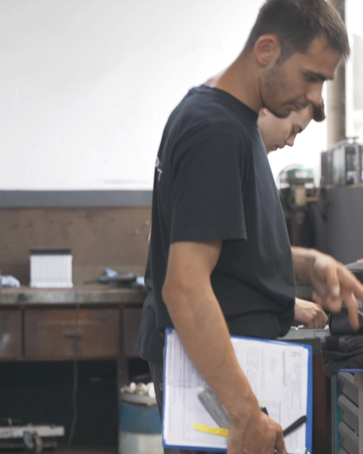 Mechaniker mit Klemmbrett in der Werkstatt des Autohauses Komet