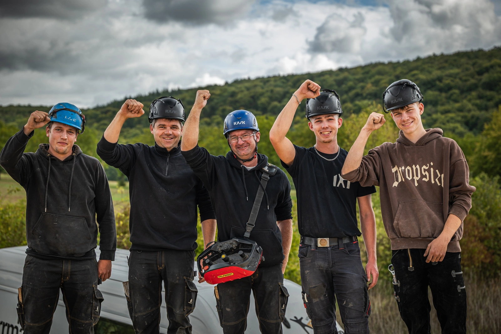 Bautrupp mit Helmen auf einer Baustelle am Hang