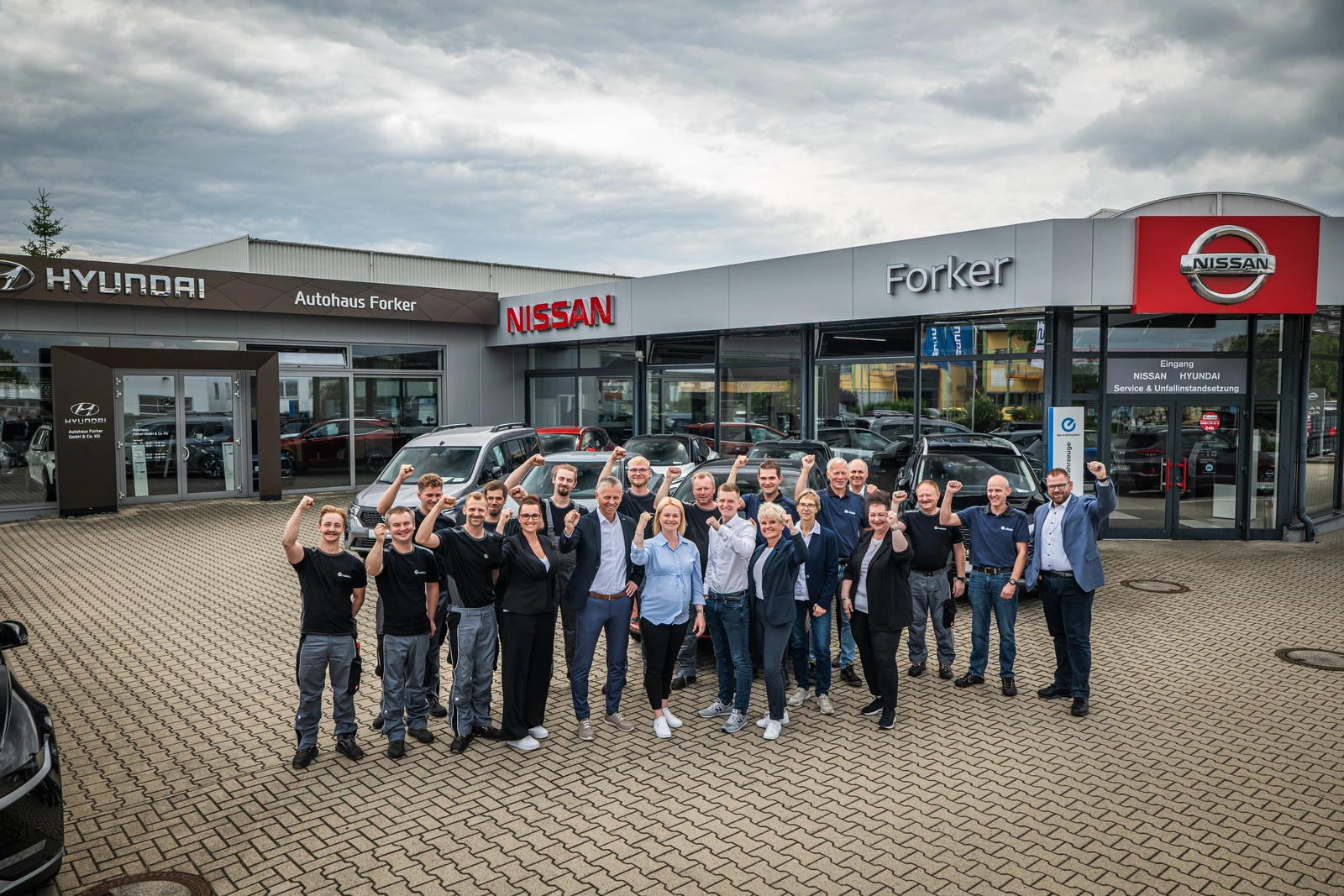 Team eines Autohauses vor dem Gebäude